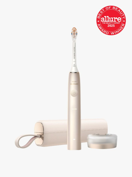 Philips Sonicare 9900 Prestige in branded gold and white color way with matching travel case and stand on light gray background with red Allure Best of Beauty seal in the top right corner